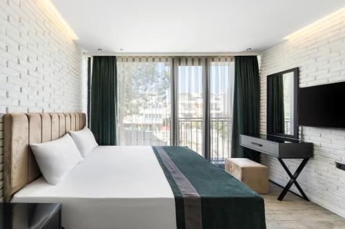 a bedroom with a large bed and a television at Nivasole Lara Pure Comfort & Style in Antalya