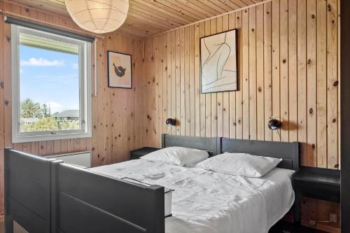 a bedroom with a bed in a wooden wall at 20315-Samso-Rosenvej-42 in Tanderup
