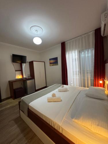 a bedroom with a large bed with two towels on it at Mesdheu ApartHotel in Durrës