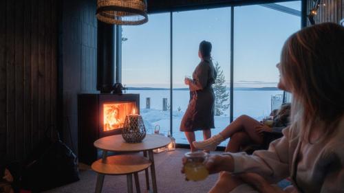 a woman standing in a living room looking out the window at Arctic Aurora Hideaway in Rovaniemi