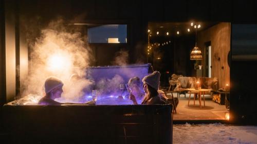 a group of people sitting around a hot tub at Arctic Aurora Hideaway in Rovaniemi