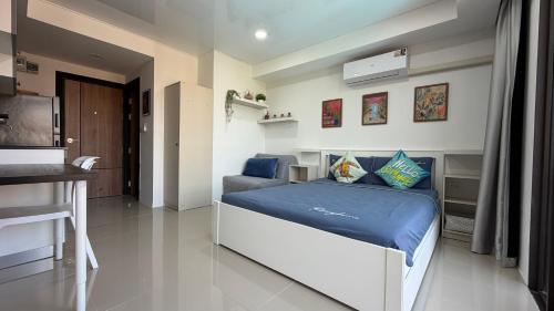 a bedroom with a large bed with blue sheets at Mai Khao 777 Beach Condo in Ban Mai Salae
