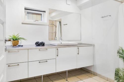 a white bathroom with a sink and a mirror at 20124-Samso-Maarup-Havn-3 in Nordby