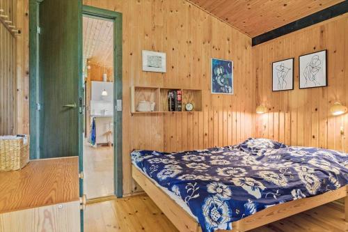 a bedroom with a bed in a wooden wall at 20119-Samso-Maarup-Skov-26 in Nordby