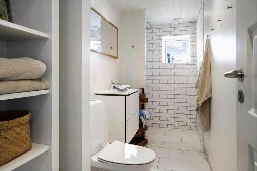 a white bathroom with a toilet and a shower at 20414-Samso-Strandvejen-63 in Ballen