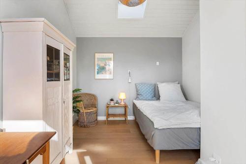 a small bedroom with a bed and a table at 20414-Samso-Strandvejen-63 in Ballen