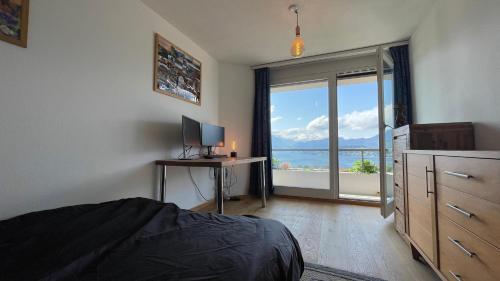 a bedroom with a bed and a desk with a television at Lakeside Lucerne in Lucerne