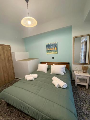 a bedroom with a green bed with two white pillows at Vattediko in Pyrgi