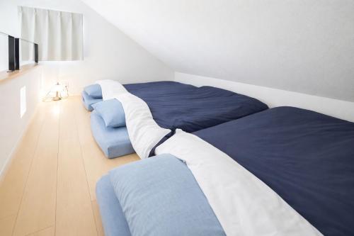 a bedroom with two beds with blue and white at GuesthouseHappytown6 in Kani