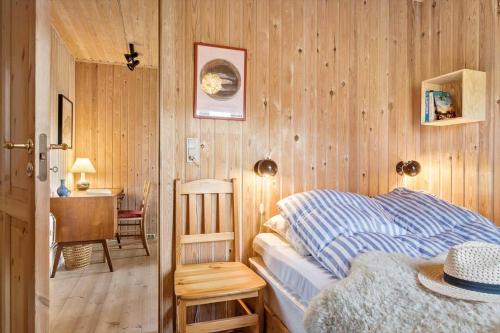 a bedroom with a bed in a wooden wall at 20613-Samso-Halemejsevej-8 in Nordby