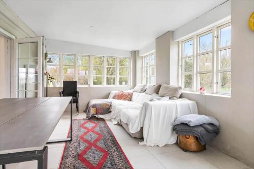 a bedroom with a bed and a table and windows at 20417-Samso-Ballenvej-26 in Ballen