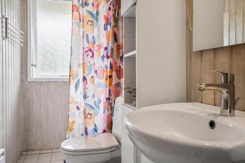 a bathroom with a sink and a toilet and a shower curtain at 20209-Samso-Rosenvej-21 in Tanderup