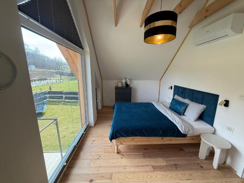a bedroom with a bed and a large window at Parkcity SPA Domek z jacuzzi w górach in Biała Niżna