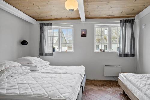 a bedroom with two beds and two windows at 20313-Samso-Orby-Hovedgade-53 in Brundbymark