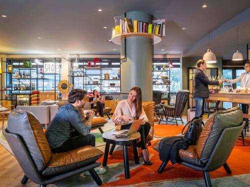Eine Gruppe von Menschen sitzt auf Stühlen in einer Lobby in der Unterkunft Aparthotel Adagio Paris Bercy Village in Paris