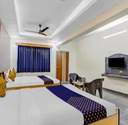 a hotel room with two beds and a tv at Hotel krishna in Mānsa