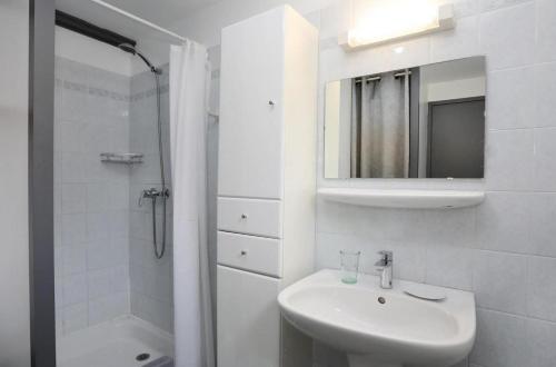 a white bathroom with a sink and a mirror at Les Portes de la Méouge anciennement Le Serpolet in Séderon