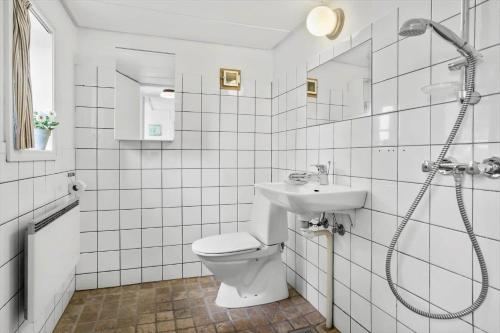 a white bathroom with a toilet and a sink at 20509-Samso-Egevej-13 in Onsbjerg
