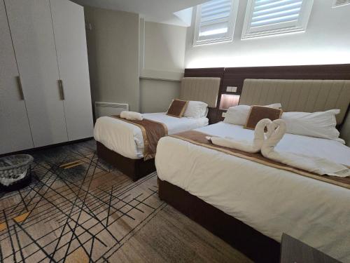 ein Hotelzimmer mit zwei Betten, auf denen Handtücher liegen in der Unterkunft Double bedroom studios in Dublin