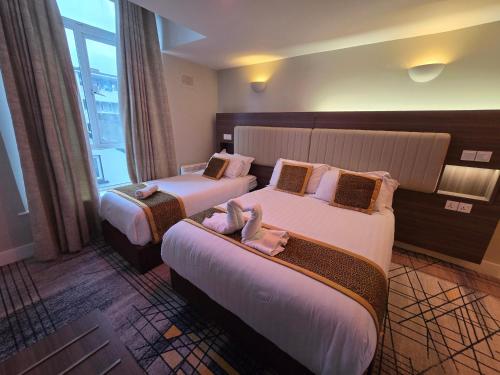 a hotel room with two beds and a window at KGT House in Dublin