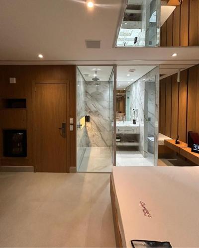 a bathroom with a glass door and a sink at Motel Queens Aeroporto de Congonhas in São Paulo