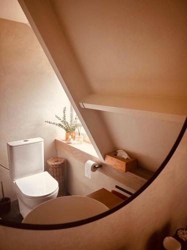 ein Badezimmer mit weißer Toilette im Treppenhaus in der Unterkunft Chalet Woods in Durbuy