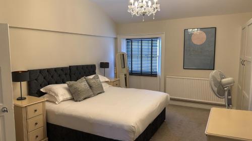 a bedroom with a bed and a lamp and a window at Townhouse Apartment in Oswestry