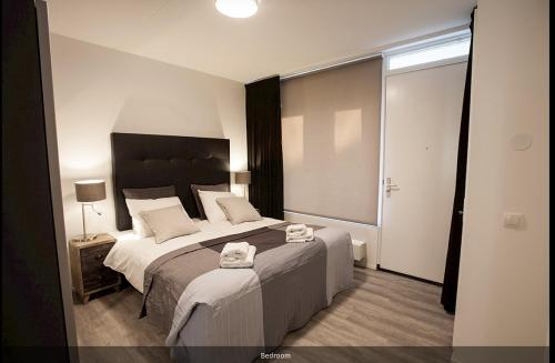 a bedroom with a large bed with towels on it at Stationsstraat 4H in Amersfoort