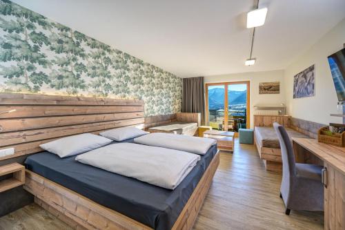 a hotel room with a bed and a desk at Allgäuer Panoramahotel in Oberstaufen