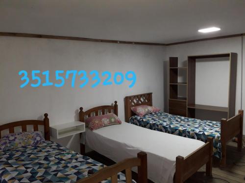 a room with two beds and a sign on the wall at La casa de Anto in Tanti