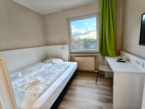 a small bedroom with a bed and a window at Bendorf Hotel by Belvilla in Bendorf