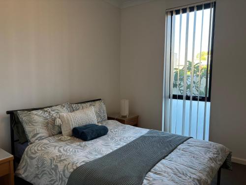 a bed with a blue pillow on it in a bedroom at Courtyard apartment in Perth