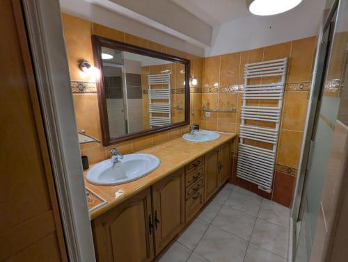 a bathroom with two sinks and a large mirror at Sol-Y-Days Avenue Camargue, grande maison proche centre et mer in Le Grau-du-Roi