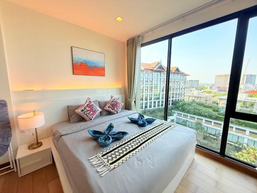 a bedroom with a bed with a large window at The Astra Condo Changkhlan in Chiang Mai in Chiang Mai