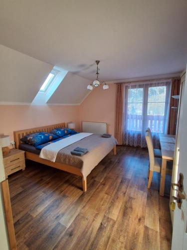 a bedroom with a large bed with a wooden floor at Penzion Na Hradčanech in Nové Město nad Metují