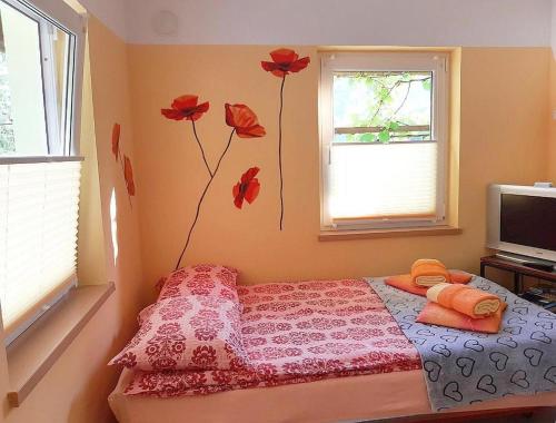 a bedroom with a bed with red flowers on the wall at Hiša Planica in Kobarid