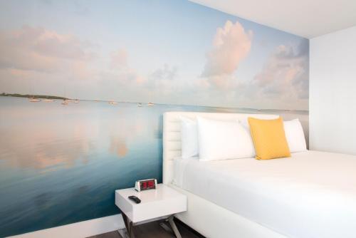 a bedroom with a bed and a view of the water at President Hotel in Miami Beach