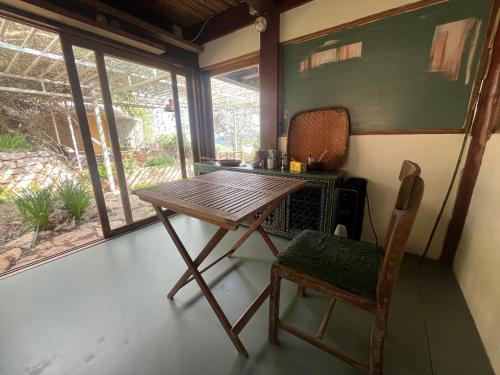 a table and a chair in a room with a chalkboard at Meek Yurt in Yodefat