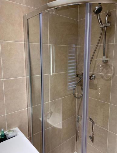 a shower with a glass door in a bathroom at Heatherlea Cottage in Skigersta