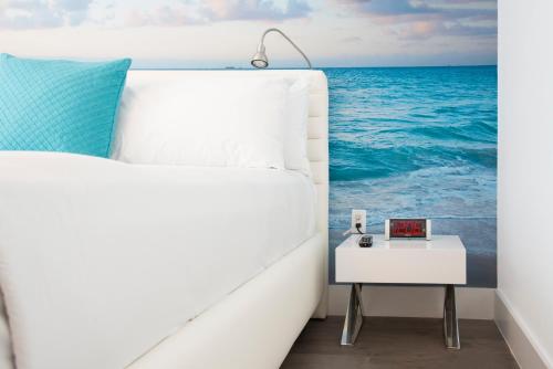 a bed with a side table next to the ocean at President Hotel in Miami Beach