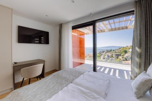 a bedroom with a bed and a large window at Carmen Residence Apartments in Opatija