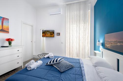 a blue and white bedroom with a bed with pillows at Mellos B&B in Naples