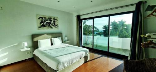a bedroom with a bed and a large window at Luxury Villas in Vila Franca do Campo