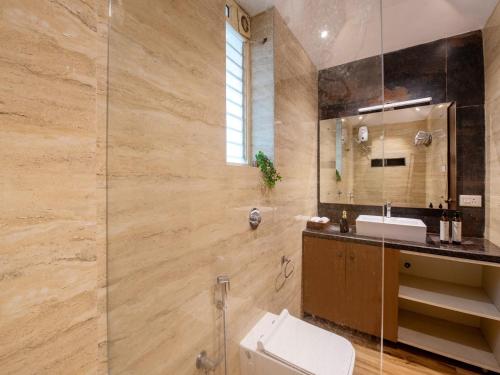 a bathroom with a toilet and a sink and a mirror at DanCenter Infinity Villa I 5BHK I Pvt Pool I Baga I GOA in Goa