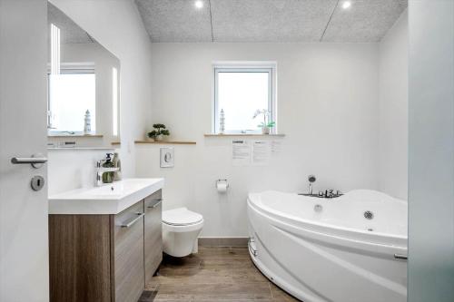 a bathroom with a tub and a toilet and a sink at FY396-Middelfart-Siriusvej-4 in Middelfart