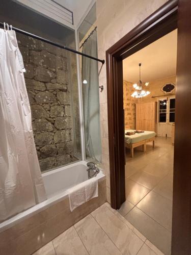 a bathroom with a shower and a bath tub at Serenity Wellness Farmhouse With Private Sauna in Nadur