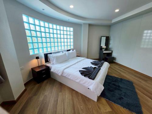a bedroom with a large bed and a large window at M-Well House in Sathani Ban Hua Mak