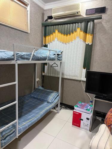 a room with two bunk beds and a television at Хостел Ганга in Tashkent