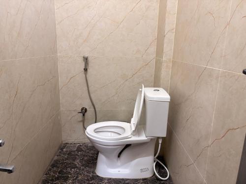 a bathroom with a white toilet in a stall at Farm Shaala in Tiruttani