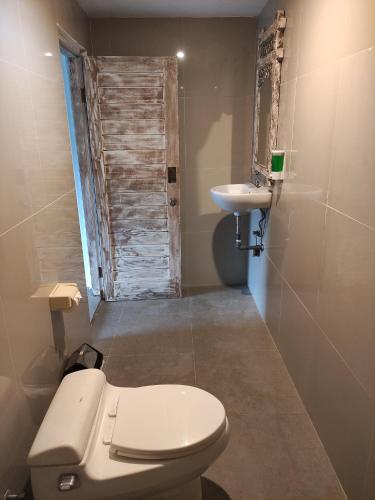a bathroom with a toilet and a sink at Karma Backpacker in Uluwatu